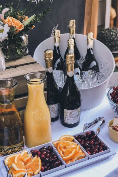 A mimosa buffet with juice, champagne, and fresh fruit