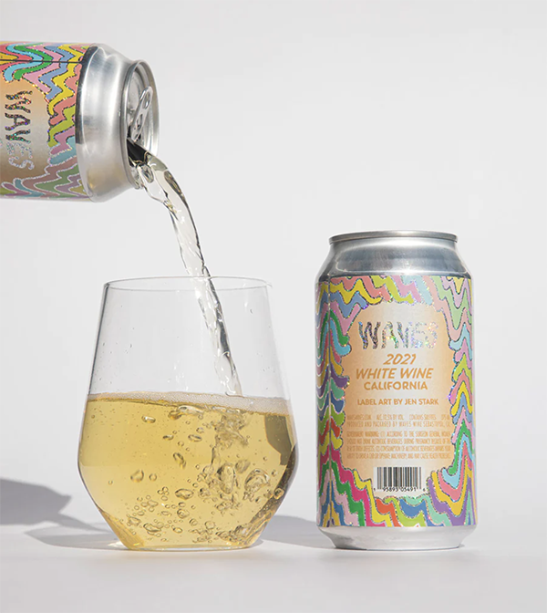 A can of white wine next to a glass of white wine