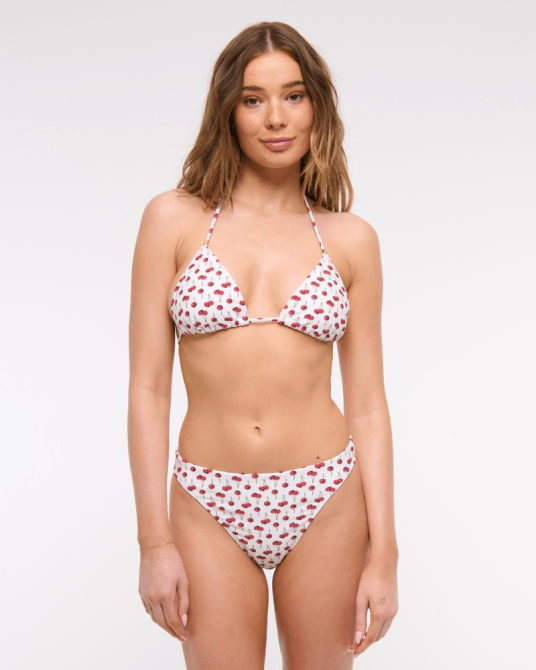 A model wearing the Abercrombie & Fitch Mid-Rise Bottom in a small white and red cherry pattern
