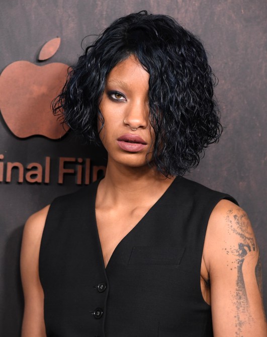 Willow Smith with curly short black hair and bleached brows.
