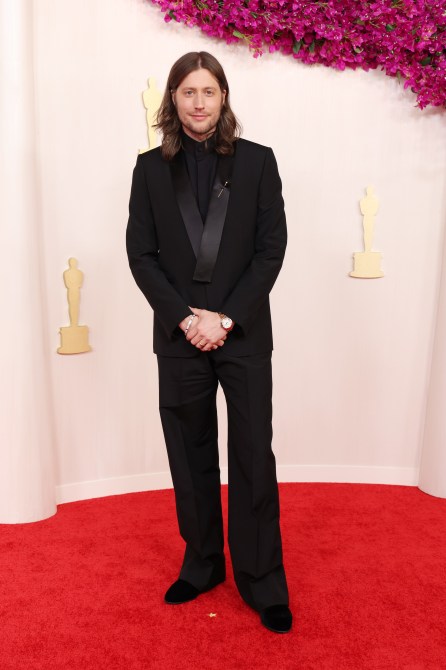 Ludwig Göransson at the 2024 Oscars red carpet in a black suit with wide-leg pants