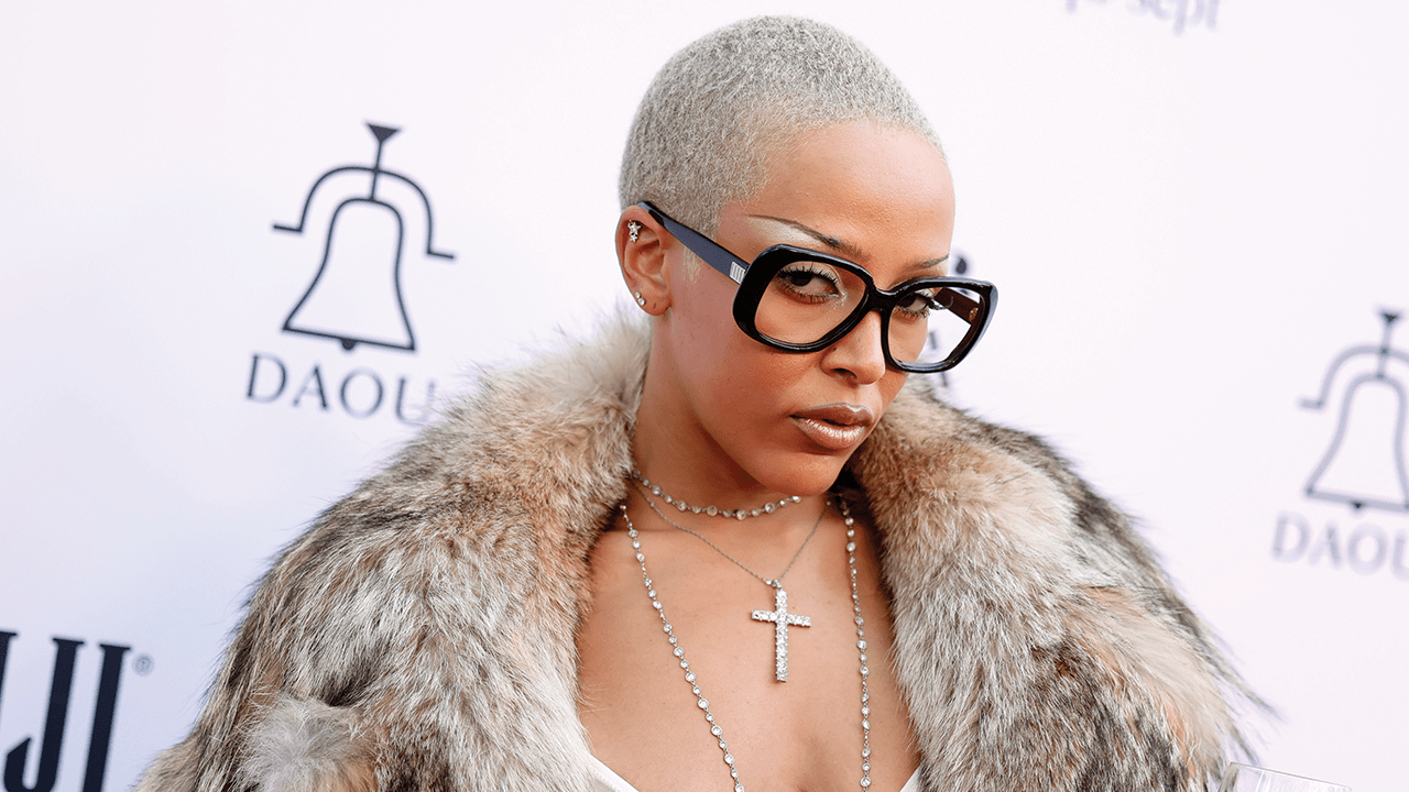 Doja Cat on the Daily Front Row red carpet wearing a fur coat and oversized glasses.