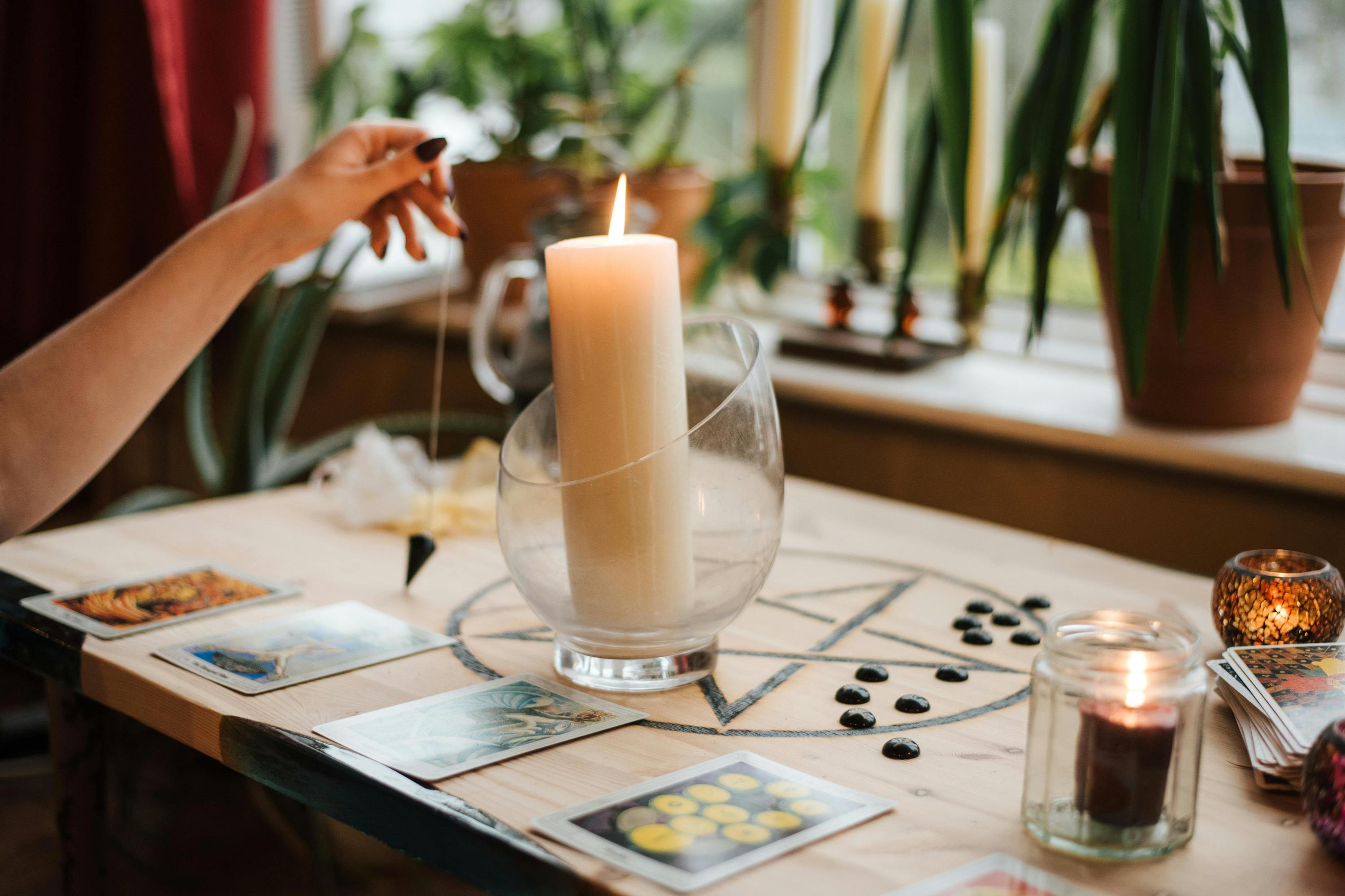 A woman lighting a candle and giving herself a Tarot card reading before the week starts