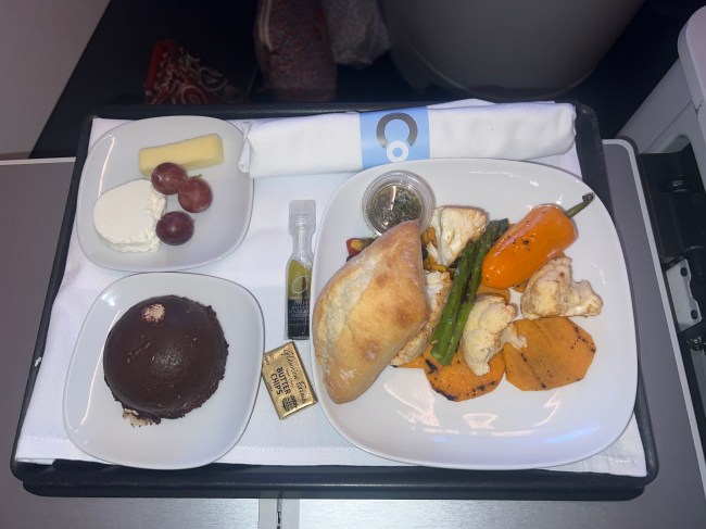 My meal on the La Compagnie flight, featuring a baguette, vegetables, charcuterie, and a chocolate dessert