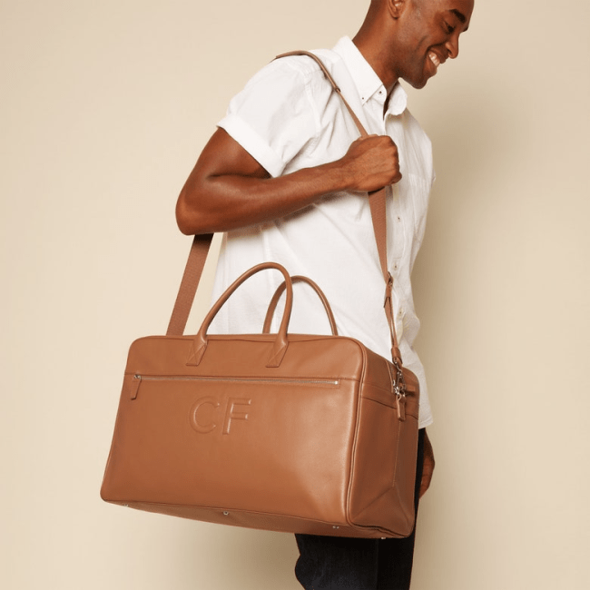 Man carrying a tan Leatherology Harwood Duffle on his shoulder.