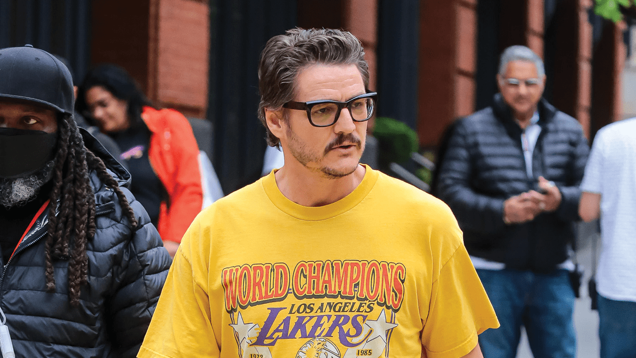 Pedro Pascal in NYC wearing black glasses and a vintage Lakers t-shirt.