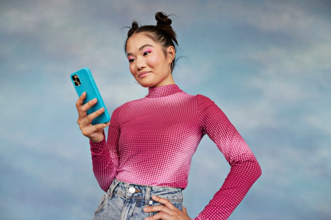 Girl using mobile phone against colored background