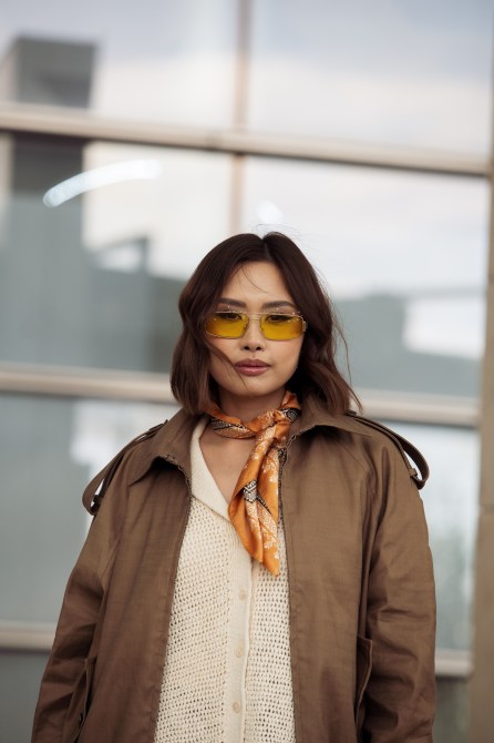 A fashion week guest wearing yellow-tinted sunglasses.