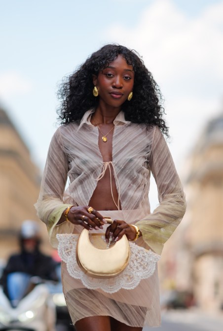 A woman carrying a crescent bag during Paris Fashion Week.