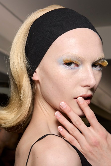 A model wearing a short French manicure.