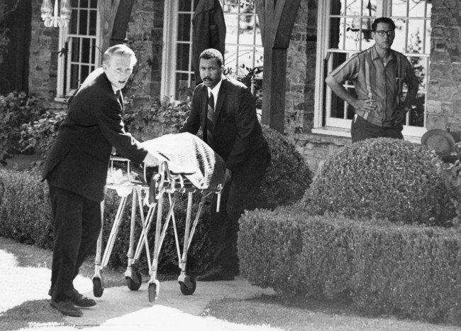 Coroner's office personnel wheel the body of film actress Sharon Tate from her home in Bel Air, California, August 9th after she and four others were found murdered. Homicide squads fanned out across Los Angeles August 11th attempting to tie together those slayings and the bizarre deaths of a married couple a dozen miles away.