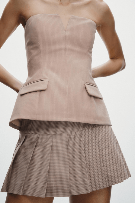 A model wearing the Zara Strapless Top in pale pink