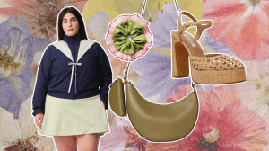 A floral background with a green crescent-shaped bag, brown block heels, a green scrunchie, and a woman wearing a navy jacket with a white bow.